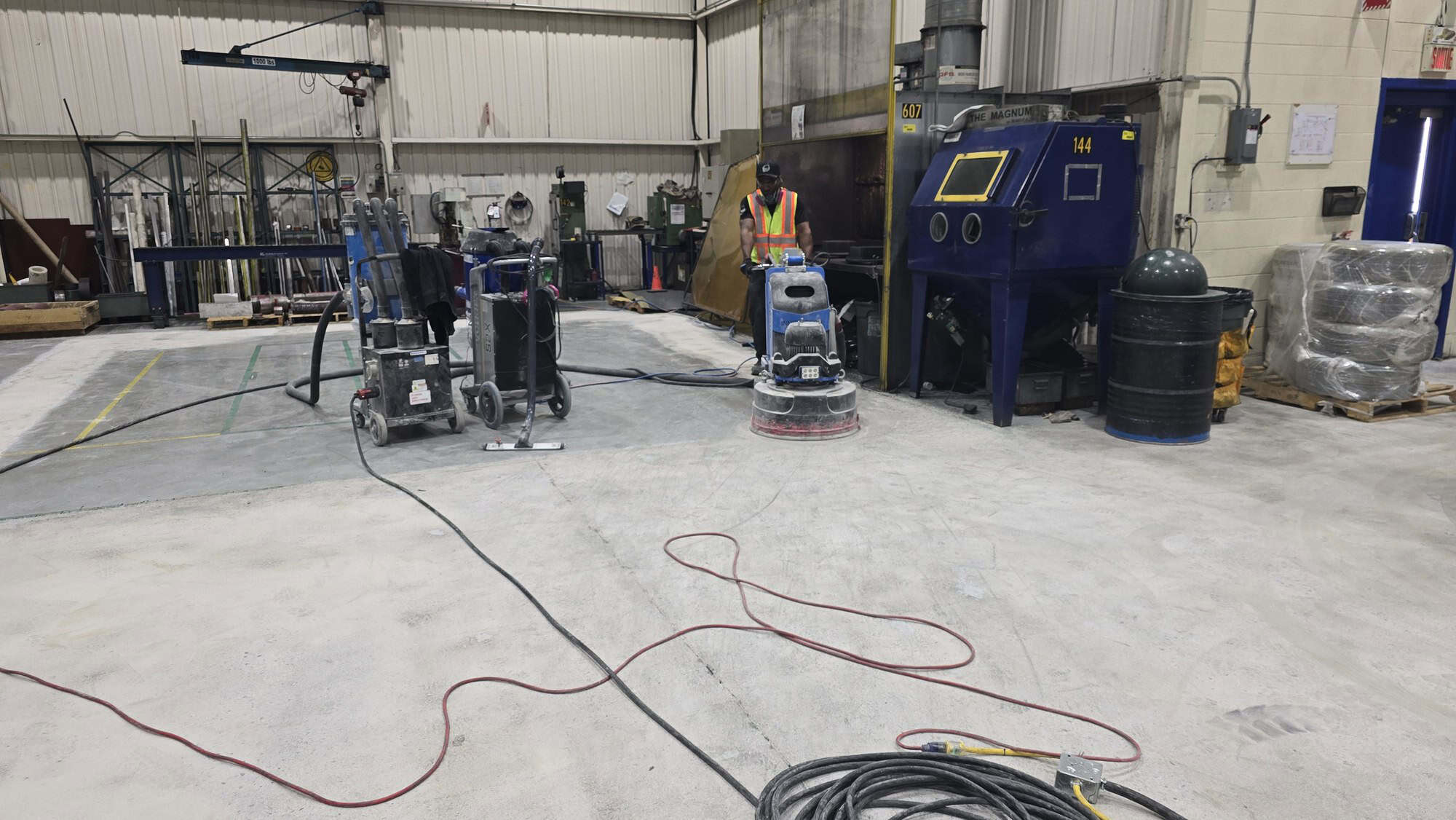 Concrete floor grinding equipment preparing an industrial slab for an epoxy system